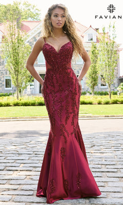 A woman wearing a deep red Faviana 11638 long prom dress, a mermaid gown with a beaded bodice and corset-style side panels.