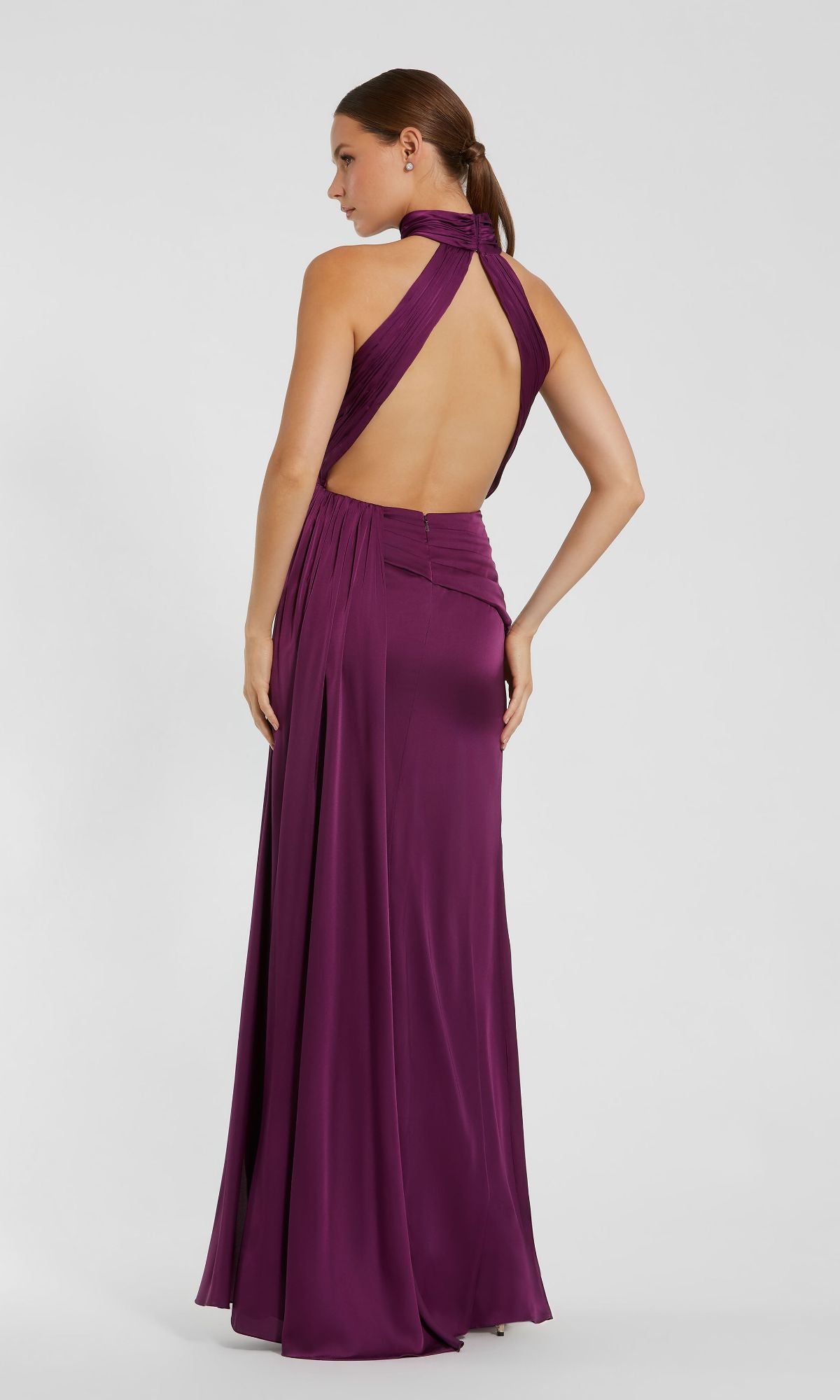 A woman wearing the Mac Duggal 11642 high-neck, floor-length prom dress poses against a plain light background.