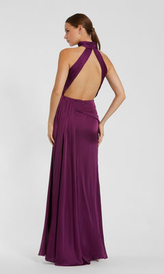 A woman wearing the Mac Duggal 11642 high-neck, floor-length prom dress poses against a plain light background.