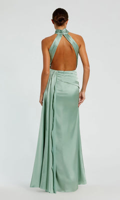 A woman models the Mac Duggal 11642 High-Neck Long Prom Dress—sleeveless, light green satin with a halter neckline and open back—against a plain background.