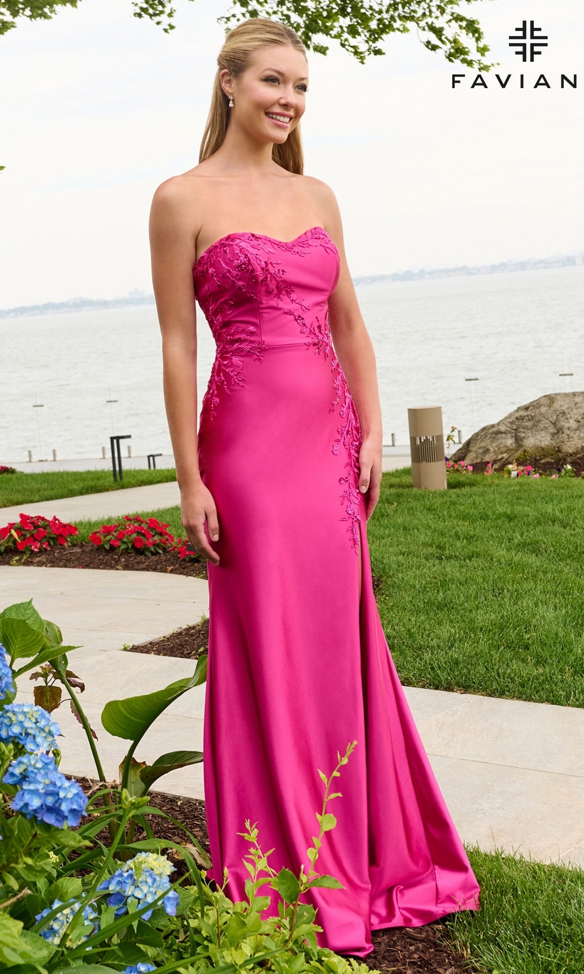 A woman in a raspberry Faviana 11647 floor-length, strapless satin prom dress featuring floral appliqué detail on the bodice and hip.