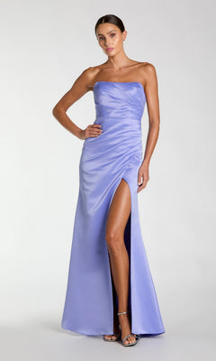 Woman wearing a strapless, floor-length Mac Duggal 11653 prom dress in sherbet orange with a thigh-high slit, standing confidently with one hand on her hip.