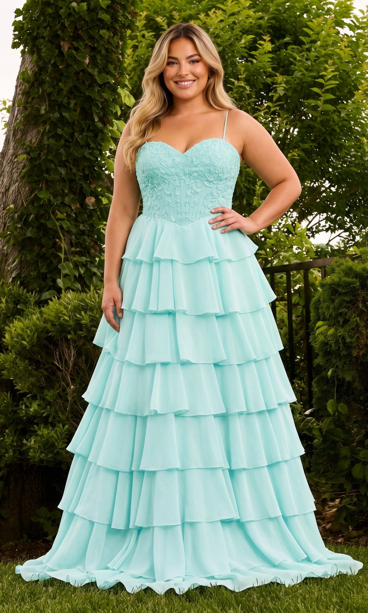 A woman wearing a sea glass blue Faviana 11665E floor-length strapless lace corset gown with a multi-tiered ruffled chiffon skirt.