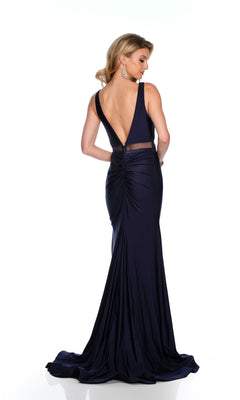 A woman models the Dave & Johnny Long Prom Dress 11666, a floor-length deep navy formal gown with an open back, as she stands and looks over her shoulder against a white background.