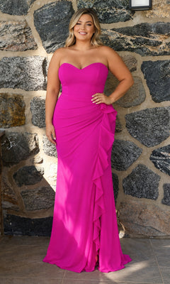 A woman wearing a bright fuchsia Faviana 11673E Long Plus-Size Prom Dress, featuring a strapless sweetheart neckline and a ruffled floor-length side slit.