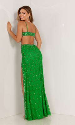 Woman wearing the Aleta Long Formal Prom Dress 1167, a bright green beaded gown featuring a long skirt and side slit, poses with her back to the camera and looks over her shoulder.