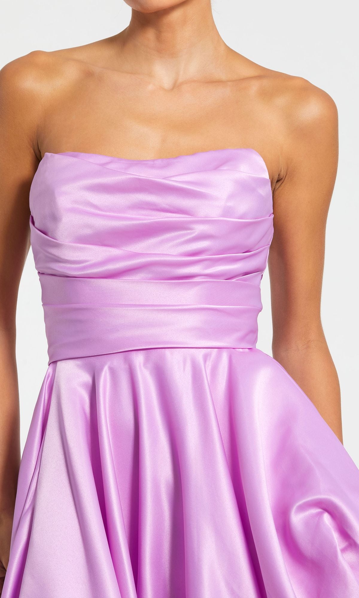 A person wearing the Strapless Balloon Prom Dress: Mac Duggal 11685 in shiny lavender, with a ruched bodice and flowing high-low skirt for an elegant evening look.