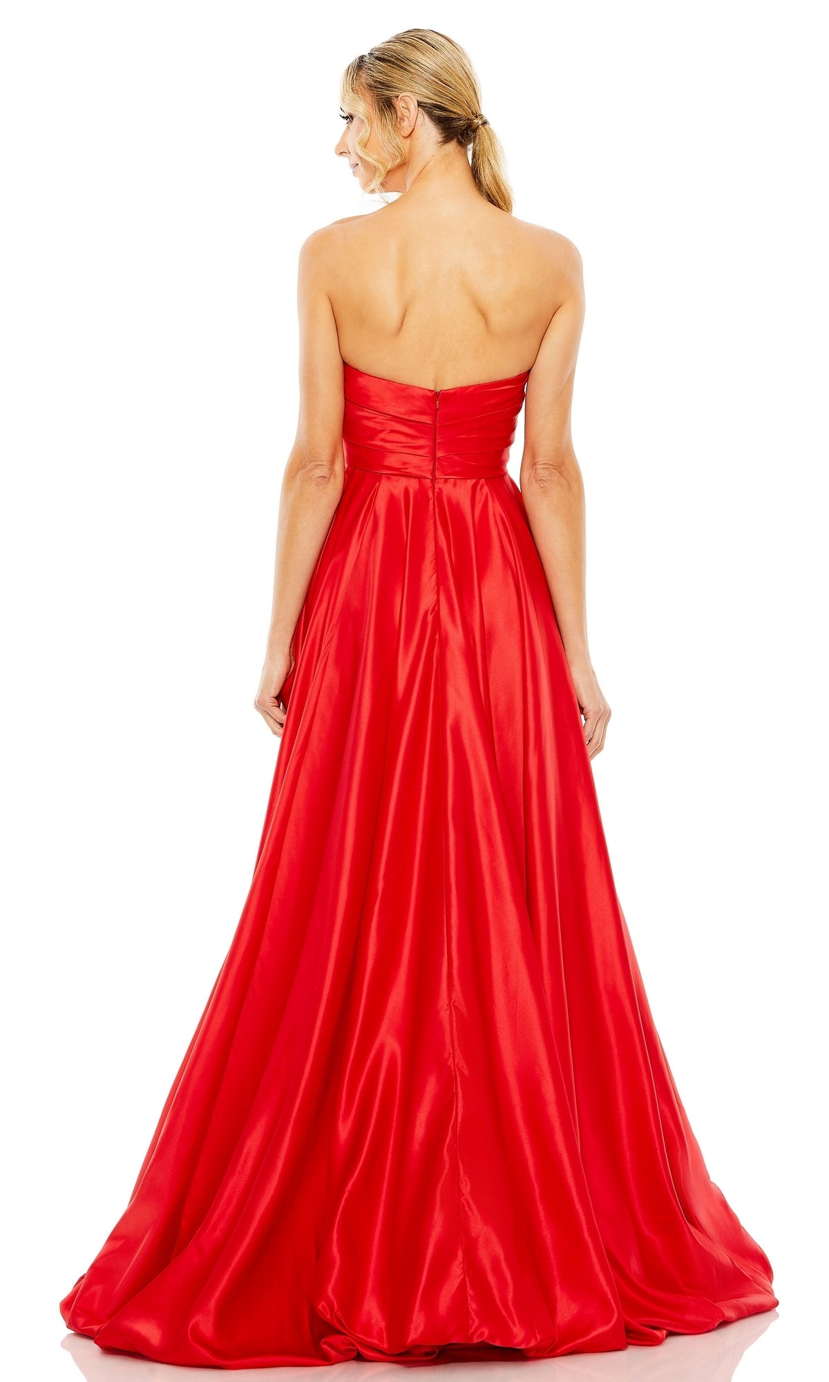A woman stands facing away, wearing the Mac Duggal 11685 Strapless Balloon Prom Dress—a floor-length, bright red satin gown featuring a fitted bodice and flowing skirt.