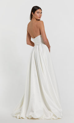 Woman poses with her back to the camera in a strapless white Mac Duggal 11685 Balloon Prom Dress against a plain white background.