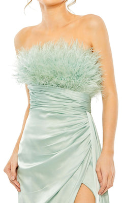 A woman wears the Long Formal Dress 11690 by Mac Duggal, a seafoam green satin strapless gown with a feathered bodice and bold thigh-high slit.