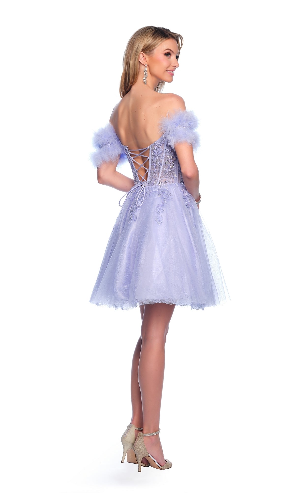 A woman wears the Dave & Johnny Feather Short Hoco Dress 11775—a light purple, off-the-shoulder dress with a beaded sheer corset, lace-up back, and feathered sleeves—paired with high heels against a white background.