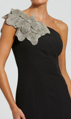 A woman wears the Beaded-One-Shoulder Prom Gown: Mac Duggal 11810, featuring a decorative silver beaded floral applique on the shoulder.