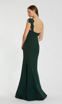 Woman wearing a dark green evening gown with floral details on a white background