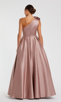 Woman wearing a one-shoulder pink ball gown on a white background