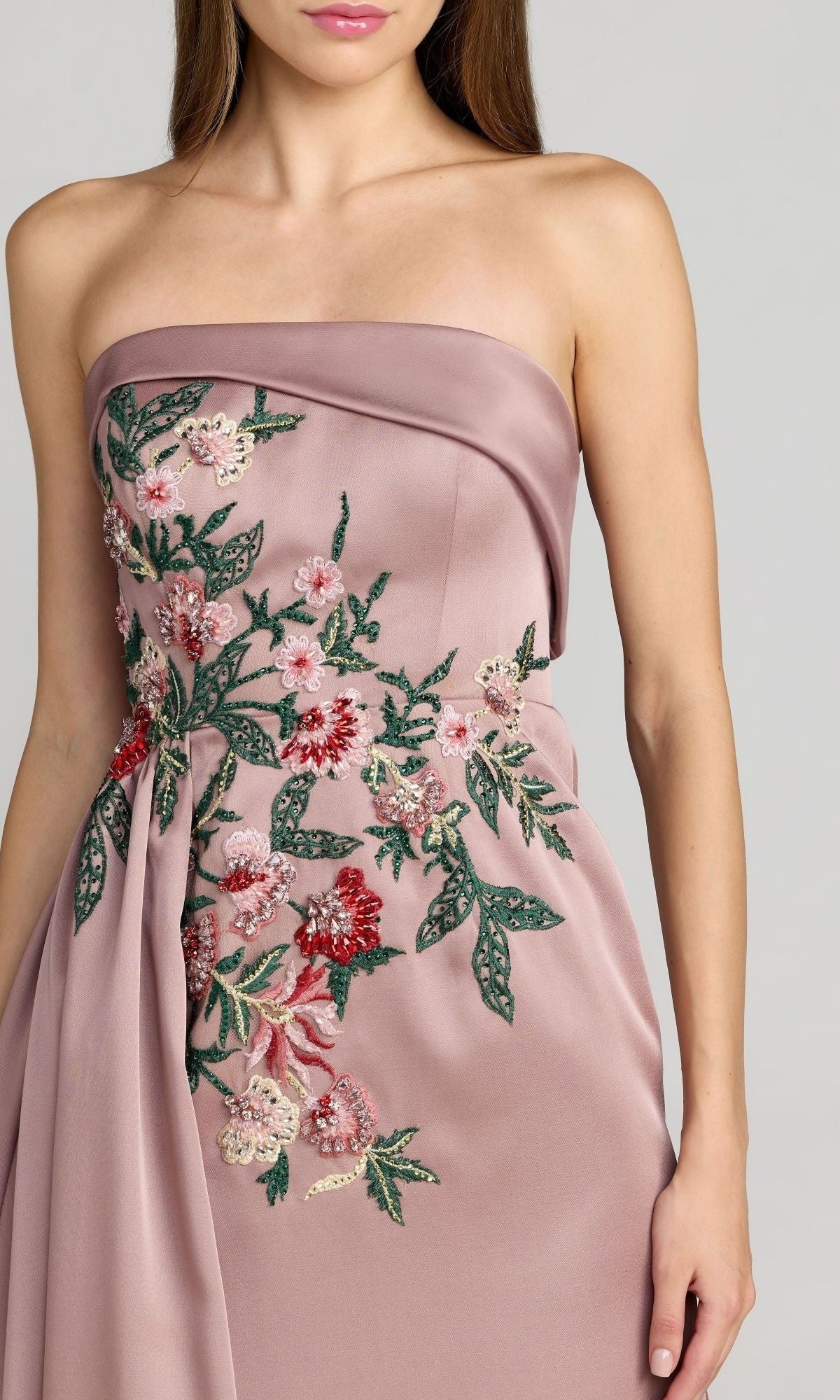 A woman wearing the Mac Duggal 11894 long formal dress—a mauve satin strapless A-line gown adorned with exquisite pink, red, and green floral embroidery on the bodice and side.