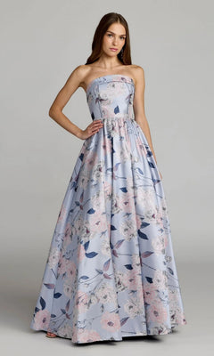 A woman stands wearing the Mac Duggal 11921 long formal dress, a strapless ballgown in a floor-length blue multi floral pattern.