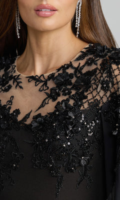 Close-up of a woman wearing the Mac Duggal 11954 long formal dress in black crepe, adorned with intricate lace and bead detailing and sequin floral embroidery. She has long dark hair, sparkling drop earrings, and neutral makeup.