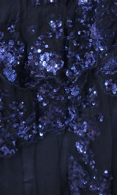 Close-up of dark blue mesh fabric with shiny blue sequins in a scattered floral pattern—featured on the Sequin Blue Homecoming Dress 11961, perfect for making a statement.