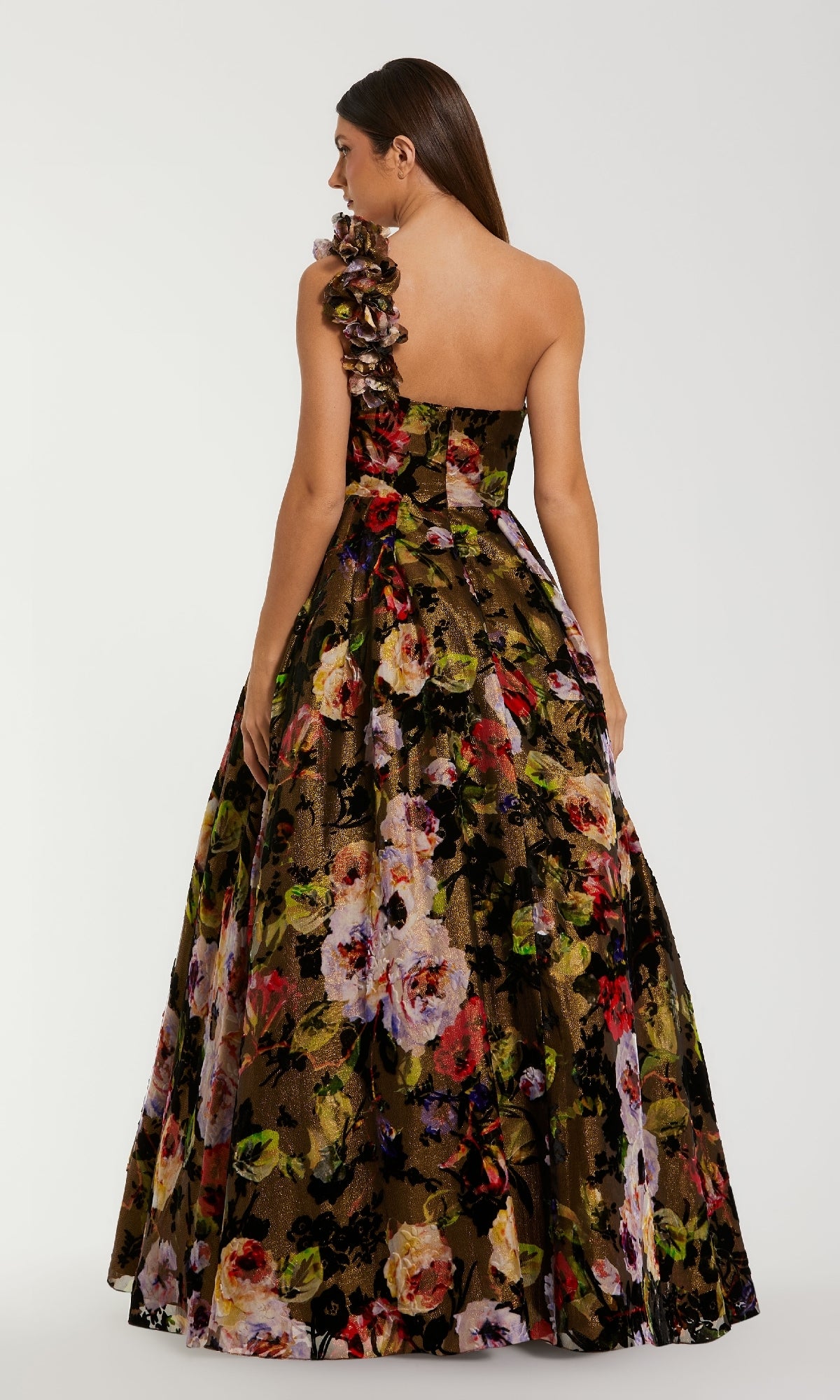 Woman wearing a floral one-shoulder ball gown on a white background