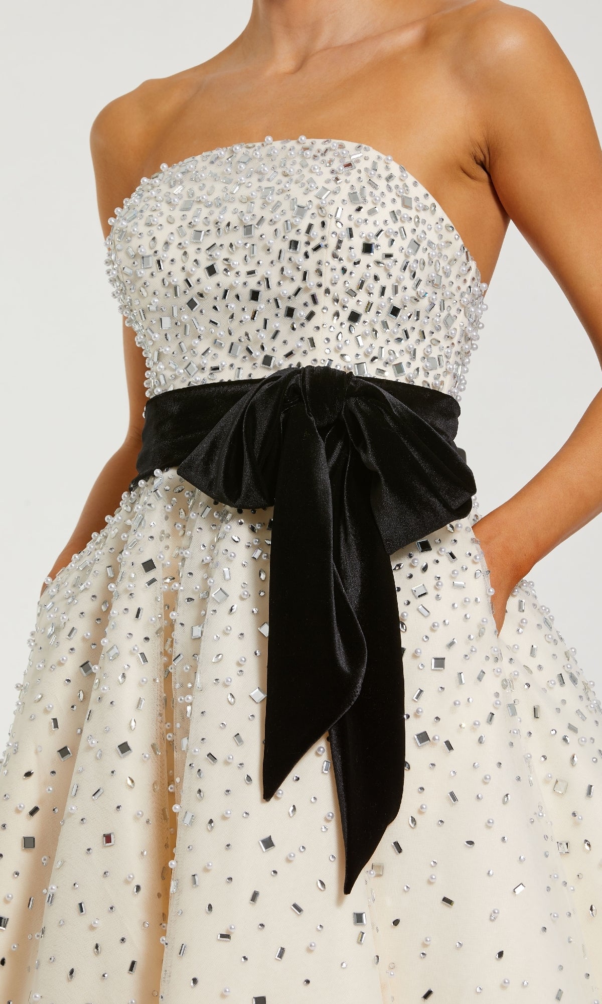 White strapless dress with black bow detail on a white background