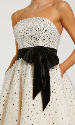 White strapless dress with black bow detail on a white background