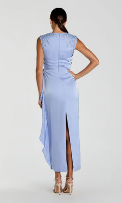 A woman wearing the Mac Duggal 11989 Satin Wedding Guest Dress in light blue, featuring beaded embroidered shoulders and a column skirt, stands with her back to the camera and beige heels.