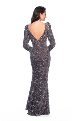A woman faces away, wearing the Dave and Johnny 12011 long prom dress, featuring silver sequins, long sleeves, a fitted silhouette, and a deep V-shaped open back.