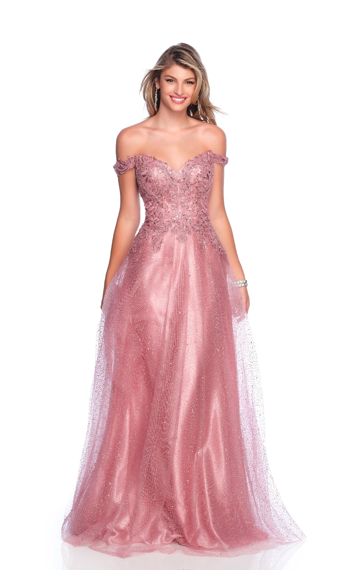 A woman smiles against a white background, wearing the Dave & Johnny 12084 Mauve Pink Prom Dress with an off-the-shoulder design, glitter tulle skirt, and intricate embellishments.