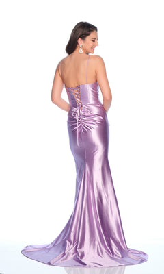A woman wears the Dave and Johnny 12220 long prom dress in metallic lilac, featuring thin straps and a lace-up back, as she stands facing away from the camera.