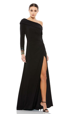 A woman models the Mac Duggal 12231 one-shoulder long formal dress—black with a thigh-high slit and beaded cuffs—paired with high heels, set against a white background.