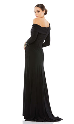 A woman stands against a white background, looking over her shoulder while wearing the Mac Duggal 12231 one-shoulder long formal dress in black.