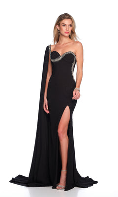 Woman in the Dave & Johnny 12232 long black prom dress featuring a one-shoulder design, thigh-high slit, corset bodice, decorative trim, and draped cape, standing against a white background.