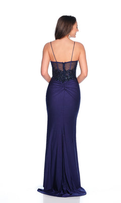 A woman faces away, wearing the Dave & Johnny 12255 long navy blue prom dress featuring a wide leg slit and a sheer, embellished back panel.