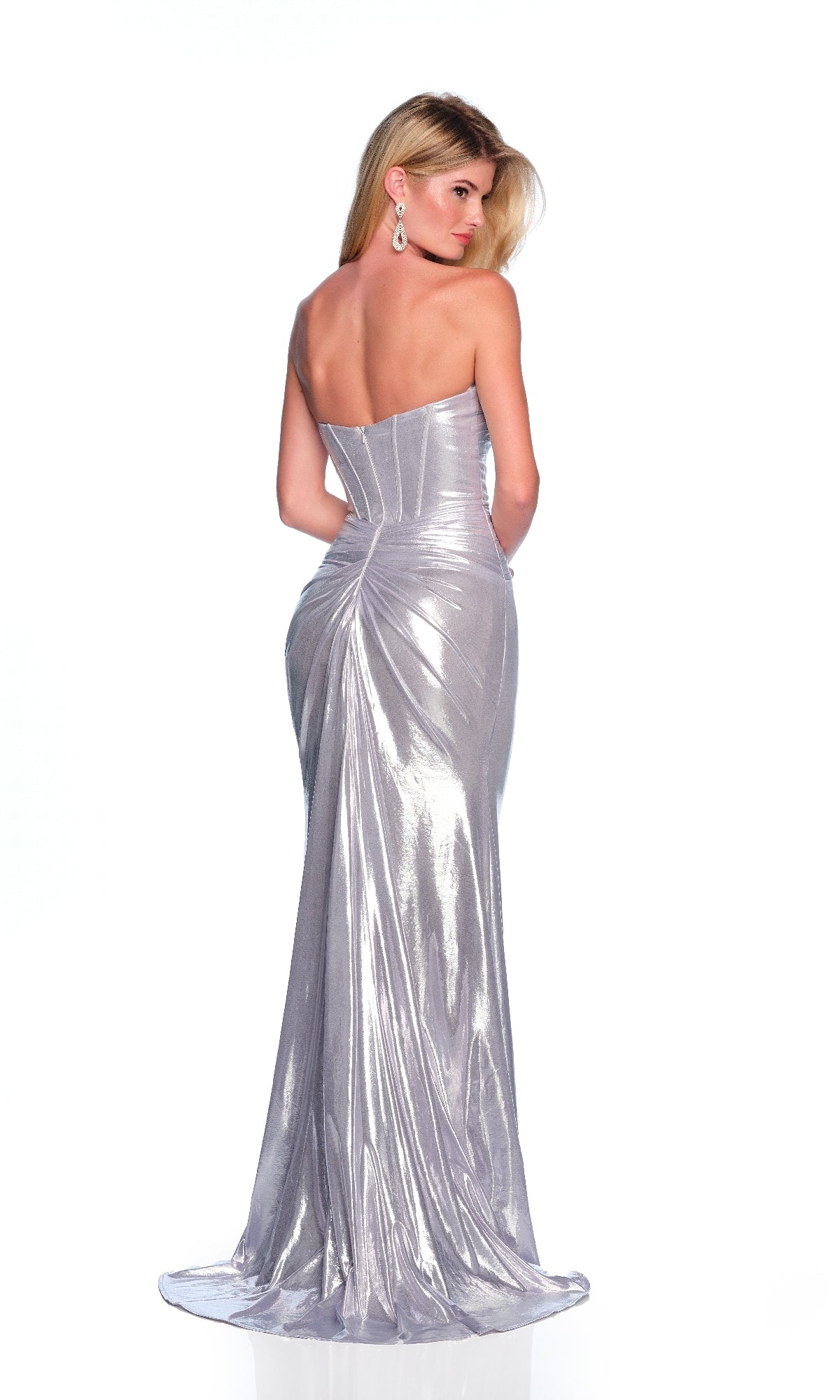 A woman poses with her back to the camera in the Long Silver Prom Dress: Dave & Johnny 12330, featuring a strapless corset bodice and shimmering metallic fabric against a white background.