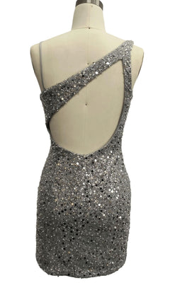 Back view of mannequin in Short Silver Homecoming Dress: 12353, featuring an asymmetrical neckline, one-shoulder strap, dramatic open back, and shimmering silver sequins.
