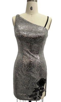 The Short Silver Homecoming Dress: 12360 is displayed on a dress form, featuring silver sequins, black floral lace near the hem, and an asymmetrical neckline for a striking look.