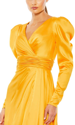 A woman wearing the Long Formal Dress 12404 by Mac Duggal, featuring long sleeves, a bright yellow satin finish, V-neckline, ruched waist, puffed shoulders, and an elegant silhouette.