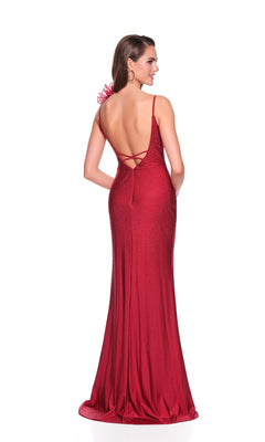 A woman poses with hands in pockets, wearing the Dave and Johnny 12412 Long Prom Dress—a floor-length, backless burgundy gown with thin straps, crisscross detailing, and subtle embellishments against a white background.