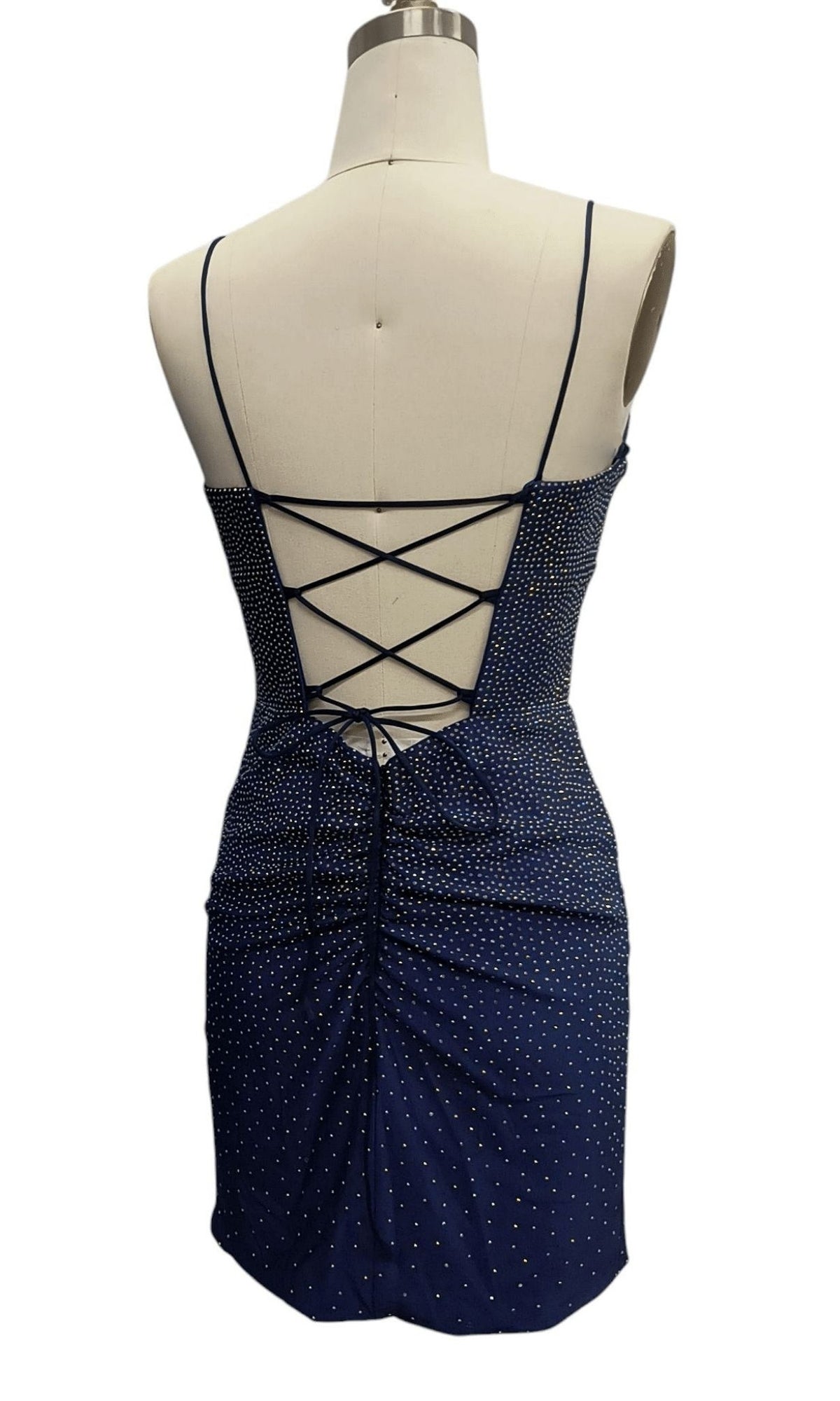 Beaded Short Hoco Dress: 12417, a navy blue mini dress with white polka dots, ruched details, and crisscross lace-up open back, displayed on a dress form.