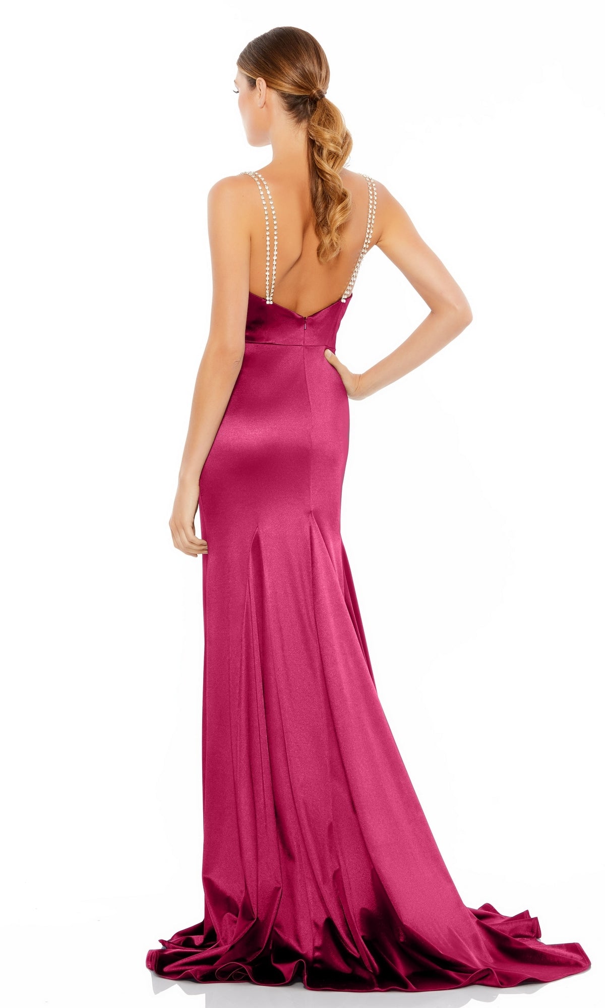 A woman wearing the Hot Pink Long Prom Dress with Sweep Train 12428 stands facing away, displaying its elegant back and her wavy, tied-back hair.
