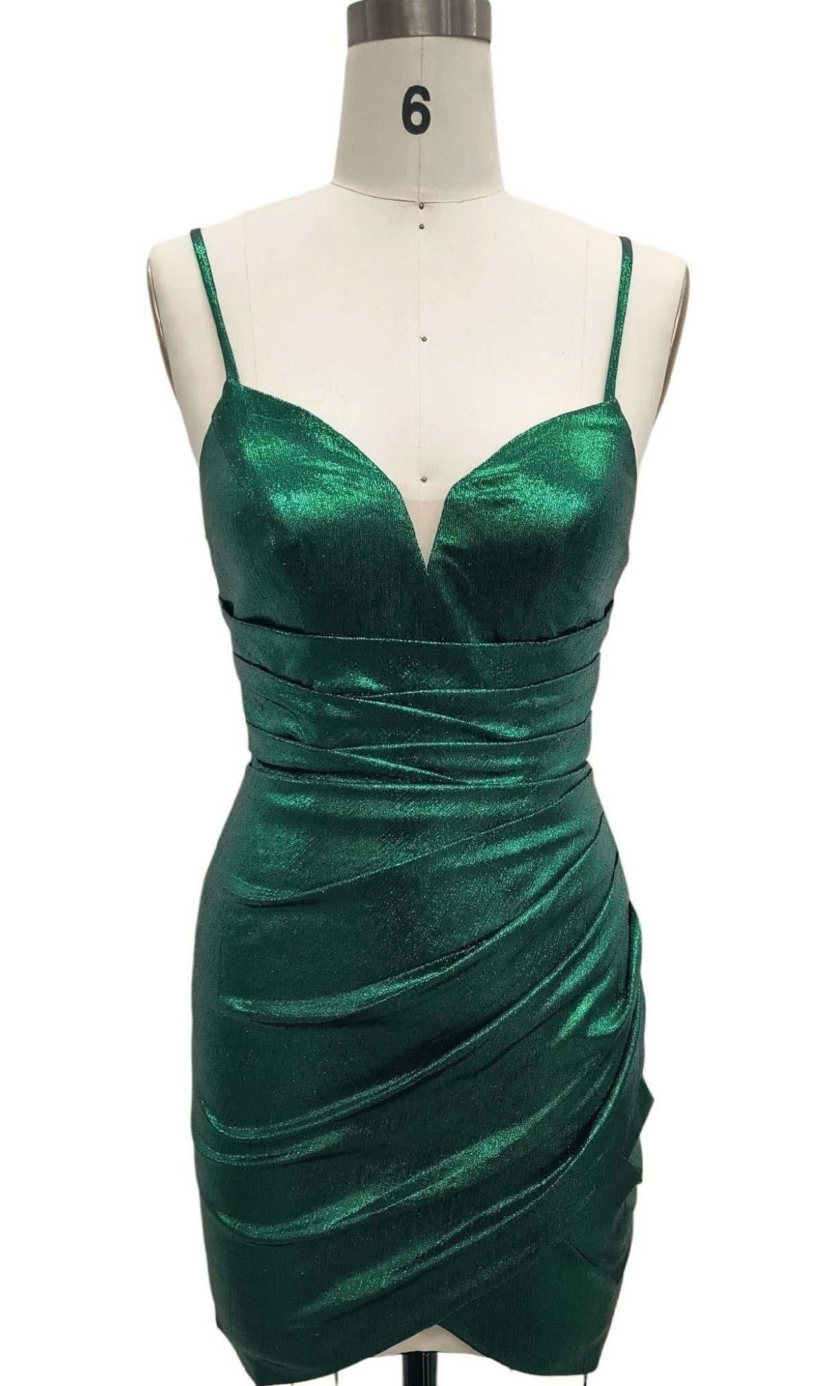 A sleeveless mannequin showcases the Ruched Green Short Hoco Dress: 12441, a metallic green mini dress featuring thin spaghetti straps and a sweetheart neckline—ideal as an emerald green homecoming dress.