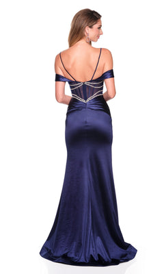 Wearing the Dave and Johnny 12576 long prom dress, a woman faces away to showcase its elegant open back. The navy blue satin gown features thin straps and sparkling beaded details for a stunning floor-length look.