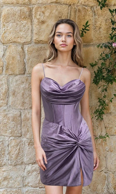 A woman stands in front of a stone wall with greenery, wearing the Short Lilac Corset Hoco Dress: 12623, a fitted purple dress featuring thin straps and a gathered knot detail at the skirt.
