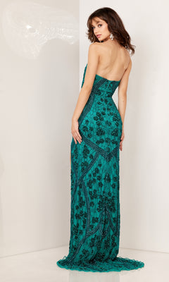 A woman in the Aleta Long Formal Prom Dress 1264, a strapless teal gown with black floral embroidery, stands in front of a white wall and looks over her shoulder.