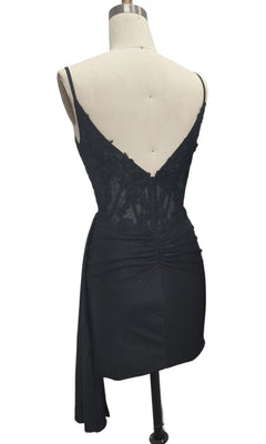 The Side-Drape Short Hoco Dress: 12658 is a black sleeveless homecoming dress with lace bodice detailing and an asymmetrical draped skirt, displayed from the back on a dress form.