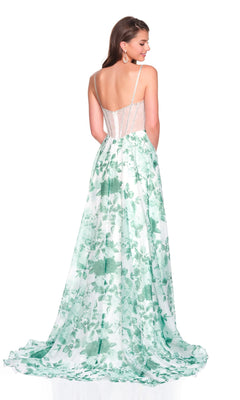 A woman stands facing away from the camera, wearing the Long Prom Dress: Dave and Johnny 12686—a green and white floral gown with thin straps, a sheer back panel, and a corset bodice.