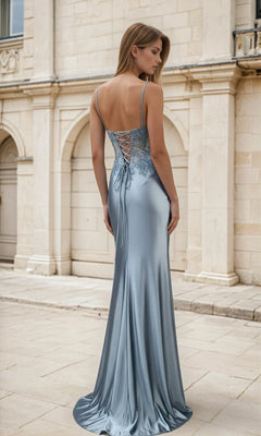 Woman wearing a blue evening gown with lace-up back in front of a classical building.