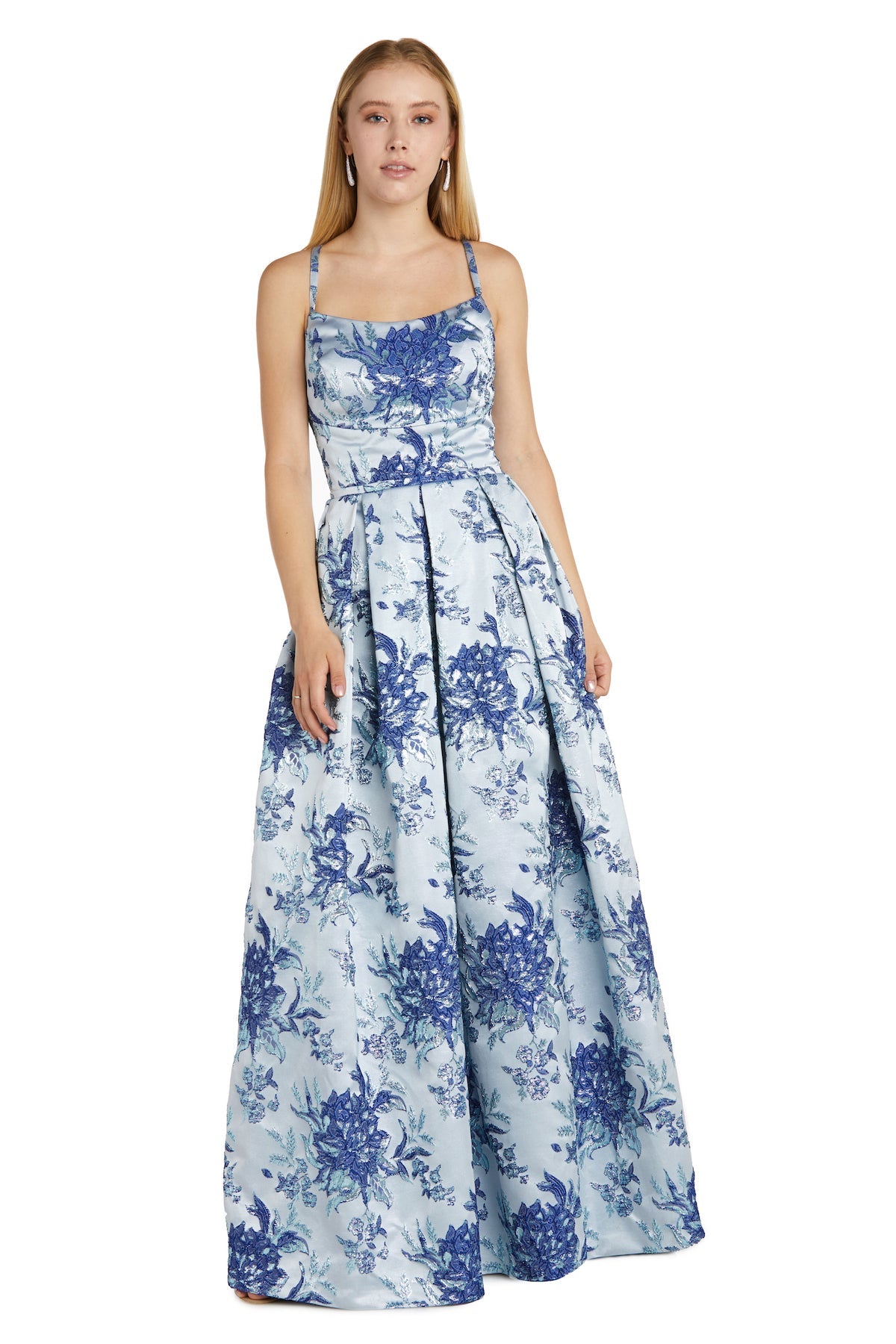 A woman stands against a plain white backdrop wearing the Blue Floral A-Line Prom Dress: Morgan 12945, featuring a sleeveless design, floor-length skirt, elegant A-line silhouette, and cut-out back.