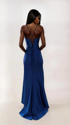 A woman faces away in the Dave and Johnny 12954 long prom dress, featuring a deep blue fitted design with crisscross straps, a lace-up corset bodice, and a floor-length satin skirt set against a plain light background.