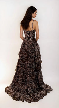 Woman showing the back of a leopard print evening gown on a white background.